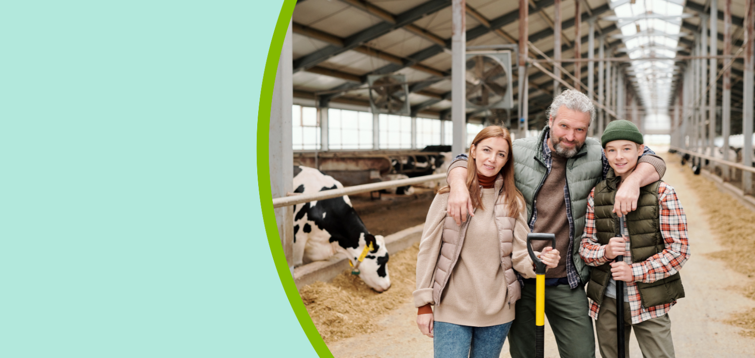 Happy family of father, mother and their son in workwear standing in cattle farm.