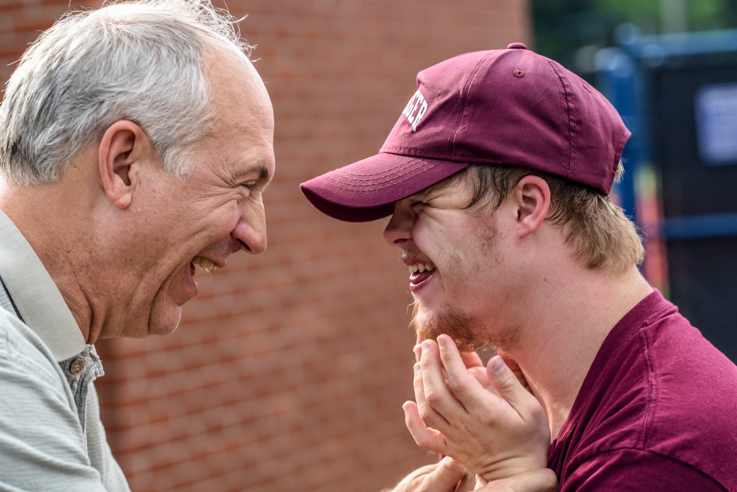 An older man laughing with a younger man