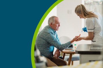 Senior diabetic man is having a check up at home from a district nurse. She is checking his blood glucose levels.