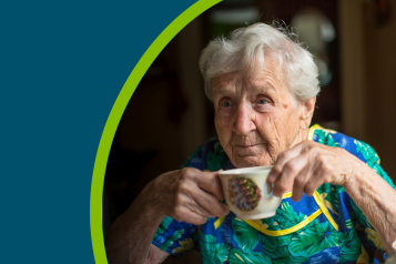 Elderly woman drinking a cup of tea alone.