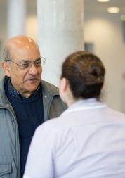 Man speaking to someone working in a health centre
